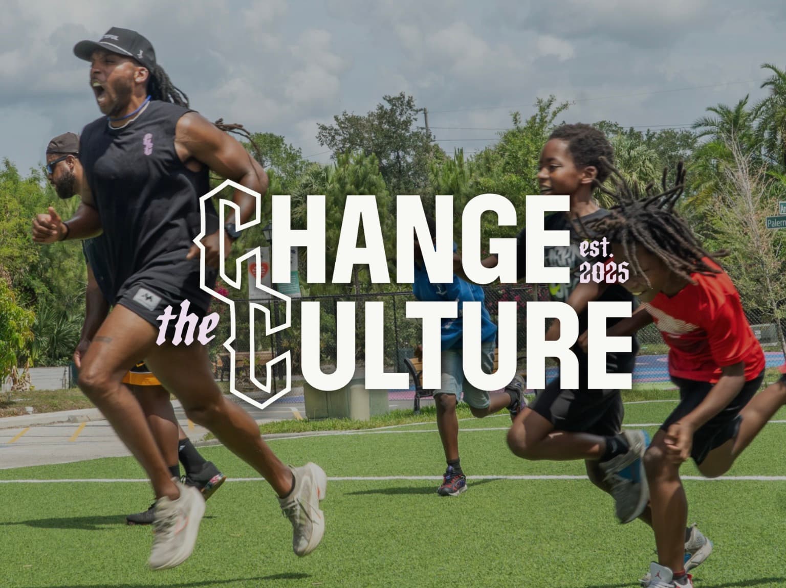 Coaches and kids sprinting across a field at Play It Forward, under the Change the Culture wordmark.