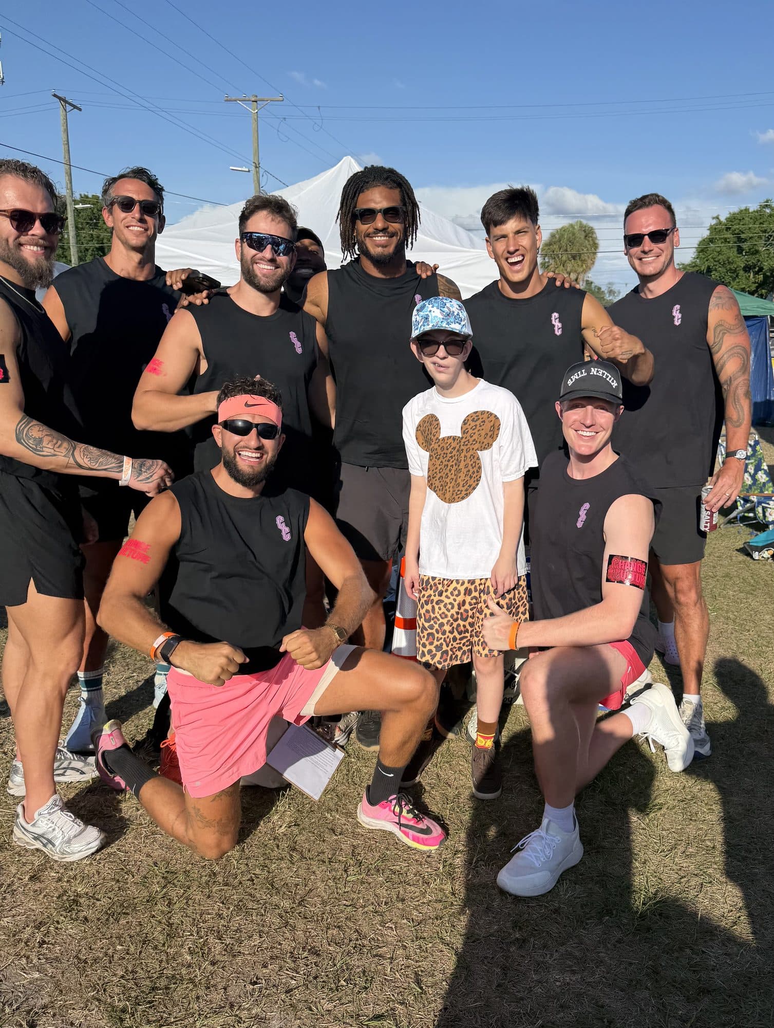The CTC crew in black tanks with a young participant at Glow Row with Project Focus.